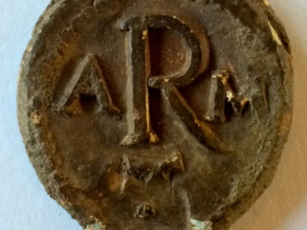 Lead seal with the letters ARM